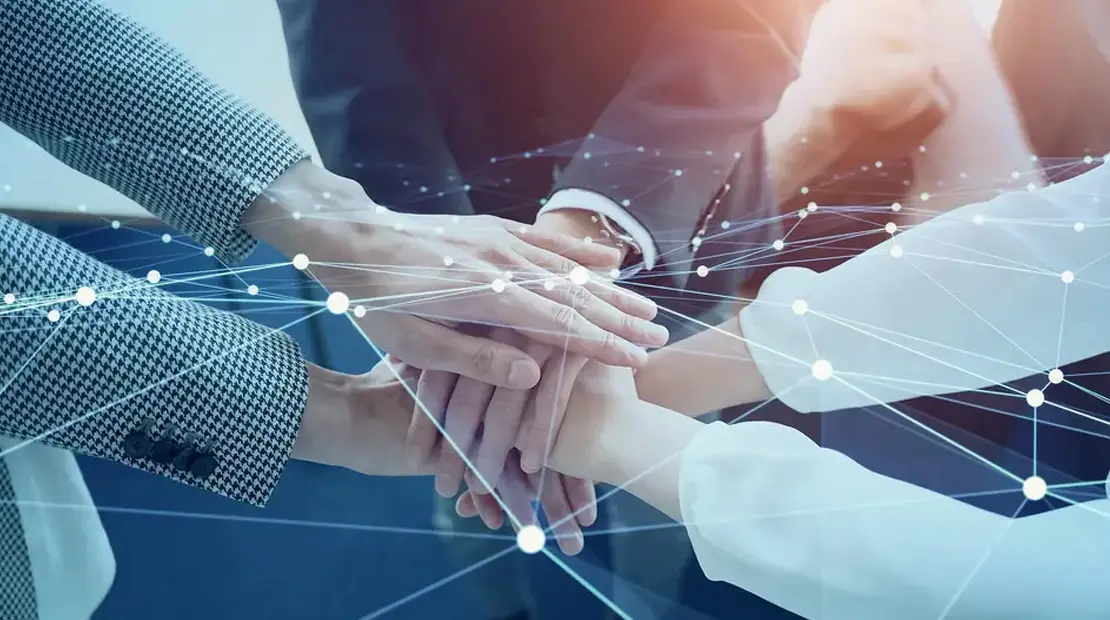 Overlapping hands as a sign of collaboration, with a symbolic digital connection network overlaid.